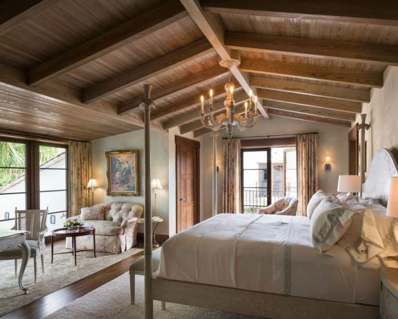 Спальня в деревенском стиле с деревянными балками теплых тонов