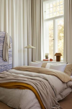 Ropa de cama y textiles de H&M Home superpuestos en un dormitorio acogedor