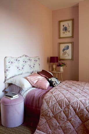 Camera da letto rosa con testiera floreale in una camera da letto francese