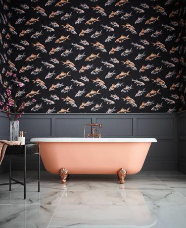 Bagno al salmone con pannelli a parete grigi e pavimento in marmo, con metà superiore della parete tappezzata in una moderna stampa di pesci scuri e chiari