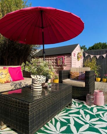 Външен двор с килим и розов чадър