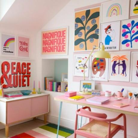 Kleines Büro mit Galeriewand voller farbenfroher Kunst