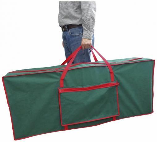 Un sac de rangement pour sapin de Noël vert foncé avec des détails rouges et une poignée renforcée