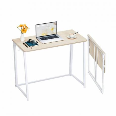 Ένα λευκό γραφείο με ένα φορητό υπολογιστή και διακοσμητικά πάνω του