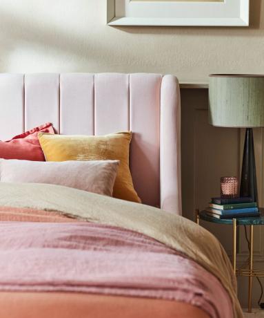 roze bed met hoofdeinde en kussens