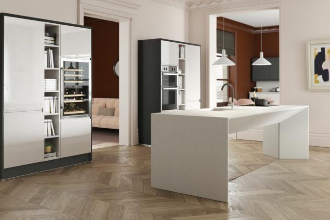 kaasaegne valge köök suure köögisaare ja kalasabapuidust põrandaga