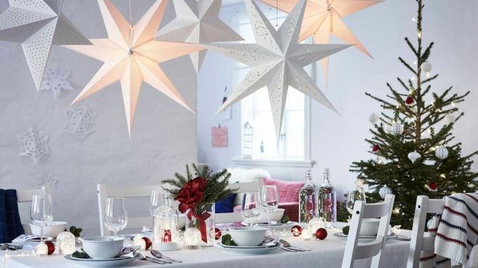 Noel için Scandi temasıyla dekore edilmiş yemek masası ve tepede LED yıldız ışıkları