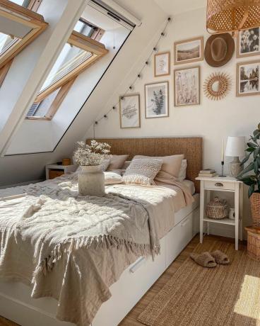Makuuhuone, jossa viisto katto ja neutraali sänky