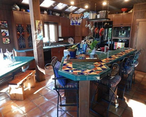 cozinha desatualizada com armários de madeira e azulejos coloridos