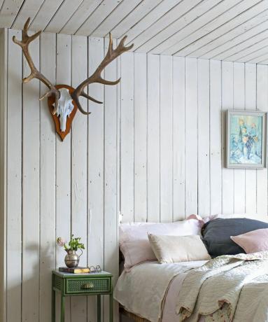 Спальня в скандинавском стиле с панелями из светлого дерева на стенах и потолке