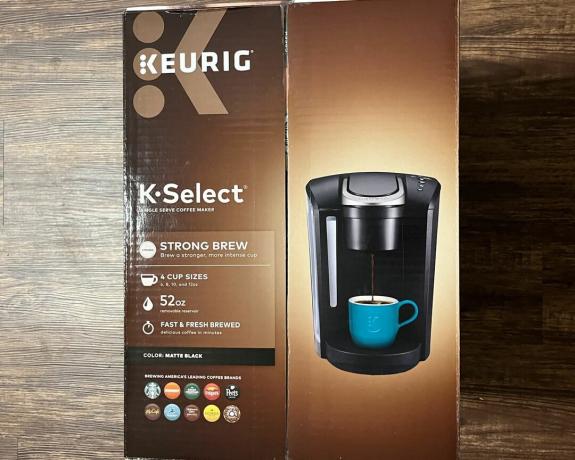 صندوق ماكينة تحضير القهوة Keurig K-Select أحادي الخدمة على أرضية صلبة مصقولة من الخشب