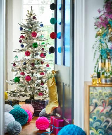яркая новогодняя елка с огромными шарами и украшениями в виде сот из бумаги