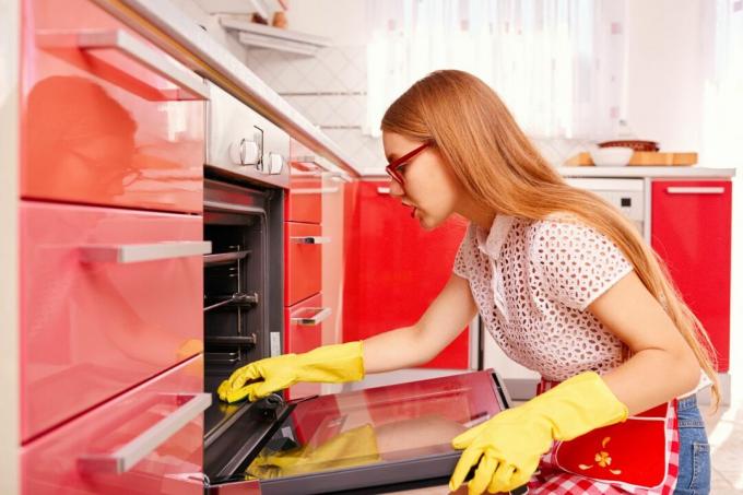 オーブンの中を掃除する女性
