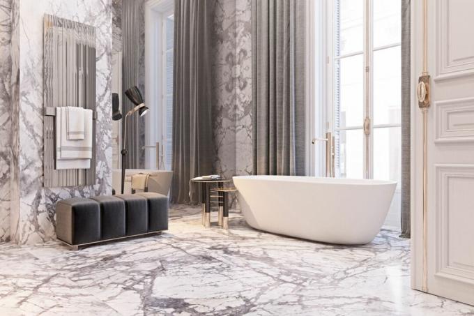 salle de bain luxueuse au fini marbre avec de grandes fenêtres, de hauts plafonds et une baignoire autoportante