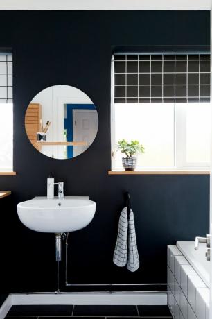 Monochromatyczna łazienka z ciemnymi ścianami i podłogą