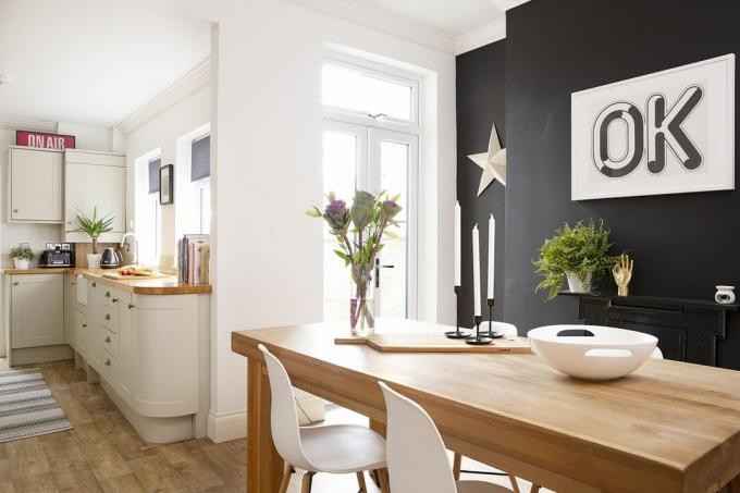 sufragerie cu un perete negru și o bucătărie în stil shaker