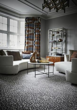 Tappeto con stampa animalier in soggiorno con divani e sedie stampa leopardata glamour