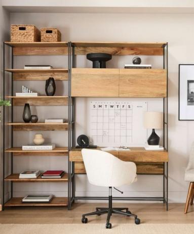 Домашний офис со столом с деревянными полками, календарем и белым стулом.