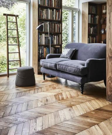 Un soggiorno con librerie, scala e pavimenti in legno