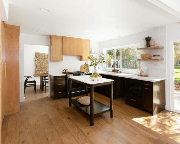 Moderni keittiö, jossa on puiset kontrastikaapit ja keskellä, vapaasti seisova apuvälinesaareke