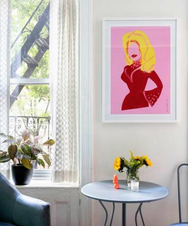 pequena mesa de jantar no apartamento de Nova York com girassóis, arte Dolly Parton e grande janela