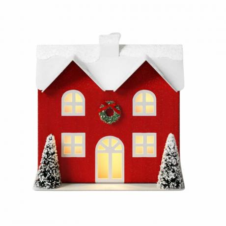 Maison rouge dans un petit village de Noël allumée à piles