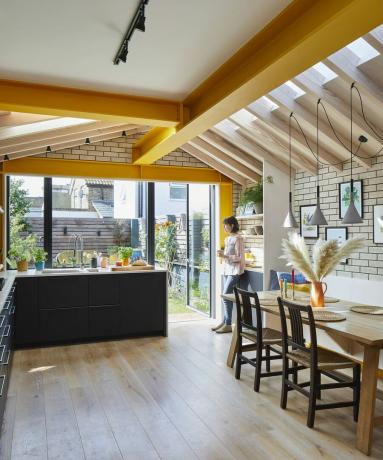 Die erweiterte Küche des Architekten George Woodrow beeindruckt mit maßgeschneiderten Schreinereien und flotten gelben Akzenten und ist der perfekte gesellige Raum für seine junge Familie