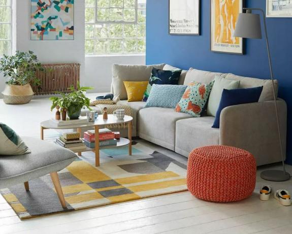 Un sofá modular gris en una sala de estar pintada de colores brillantes
