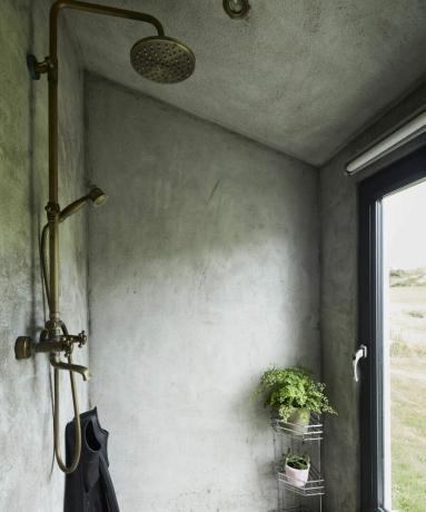 Uma sala úmida com tinta verde texturizada e prateleiras de banheiro