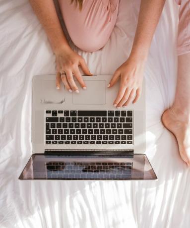 Mulher em seu laptop na cama