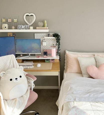 neutraali harmaa makuuhuone, jossa on työpöytä ja tietokone sekä vaaleanpunaisia ​​aksentteja