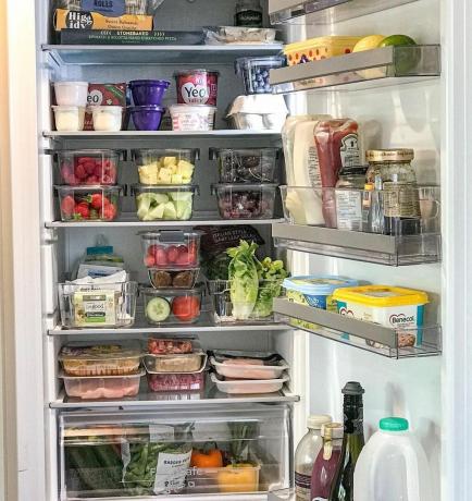 Un frigorifero con generi alimentari conservati in scatole organizzative