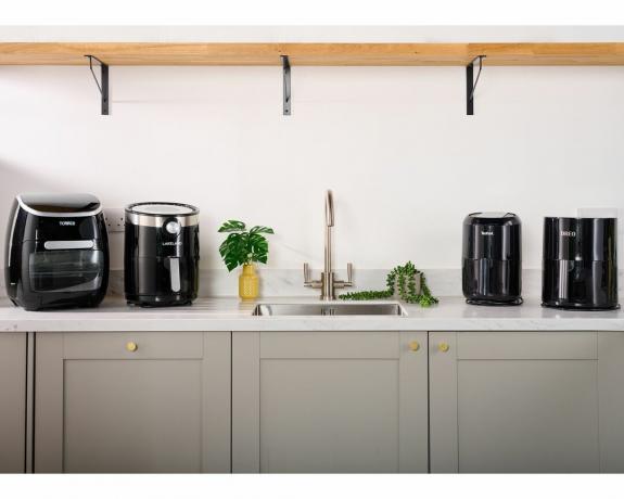 Uma seleção de fritadeiras de ar da Tower, Lakeland, T-fal e Dreo em cozinha cinza moderna na bancada