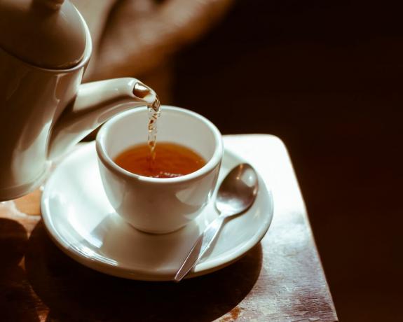 Tasse à thé sur soucoupe, avec du thé versé