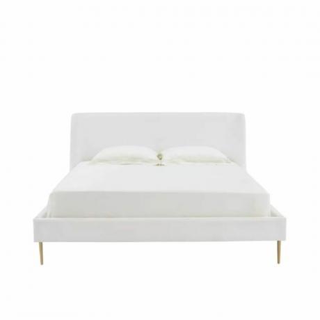 Un letto imbottito bianco con gambe dorate
