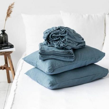 ベッドの上の最高のリネン布団カバーと掛け布団の差し込みと枕の接写 