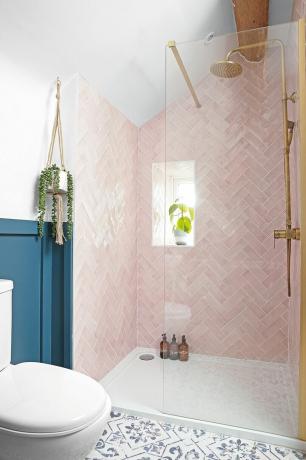 Bezbariérový sprchovací kút so sklenenou zástenou a ružovými obkladmi na stenách