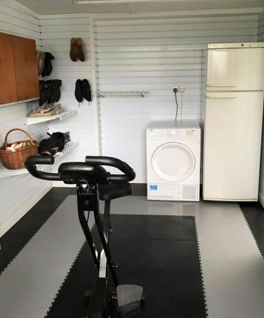 Ein Garagen-Heim-Fitnessstudio mit Waschmaschine und Kühlschrank