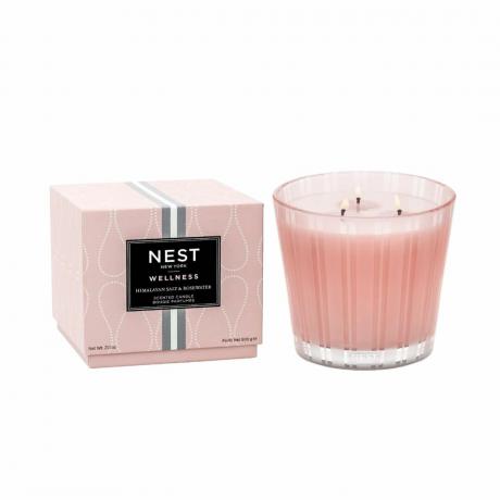 Rožinė Nest žvakė šalia rožinės dėžutės