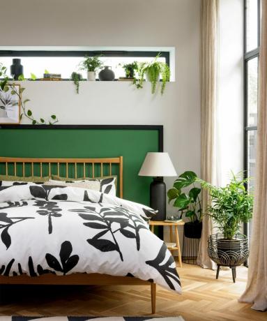 Naturalistisches Schlafzimmer mit hellem Parkettboden, bedruckter Bettwäsche auf Holzrahmenbett, schmalem Fensterlicht und großen Fenstern im Crittall-Stil – Habitat