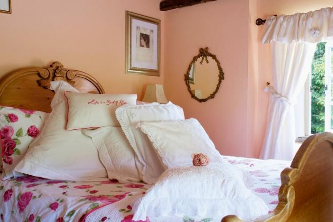 ห้องนอน ผนังสีชมพู หมอนอิง เตียงไม้ กระจก ผ้าม่าน