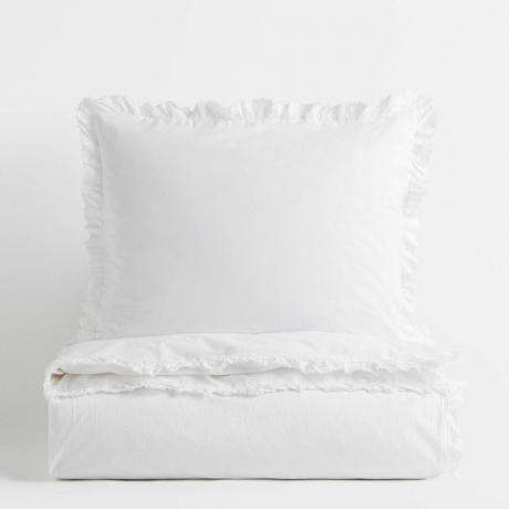 Biancheria da letto bianca piegata con cuscino