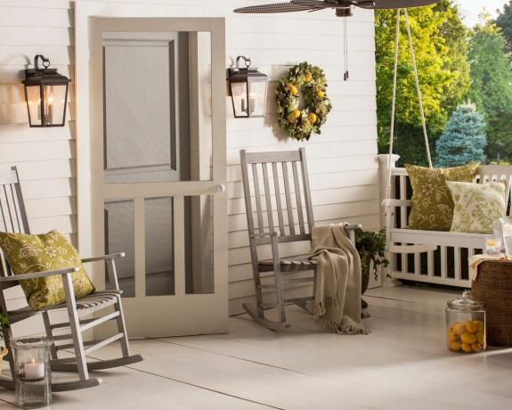 Přední veranda od Wayfair se šedou houpací židlí a lavicí, věncem a závěsným světlem