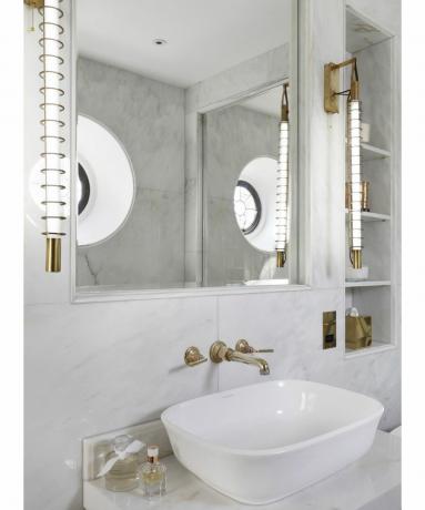 Baltā marmora vannas istaba ar iebūvētiem Viktorijas un Alberta plauktiem