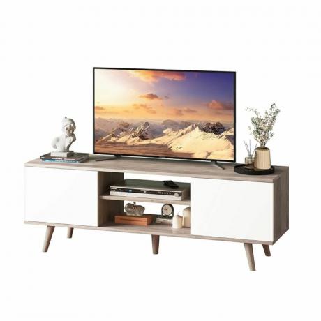 Baltas televizoriaus stovas su televizoriumi ir dekoru ant jo