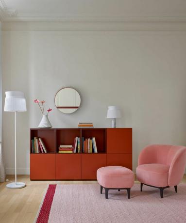 гостиная с розовым креслом и красным шкафом для хранения вещей
