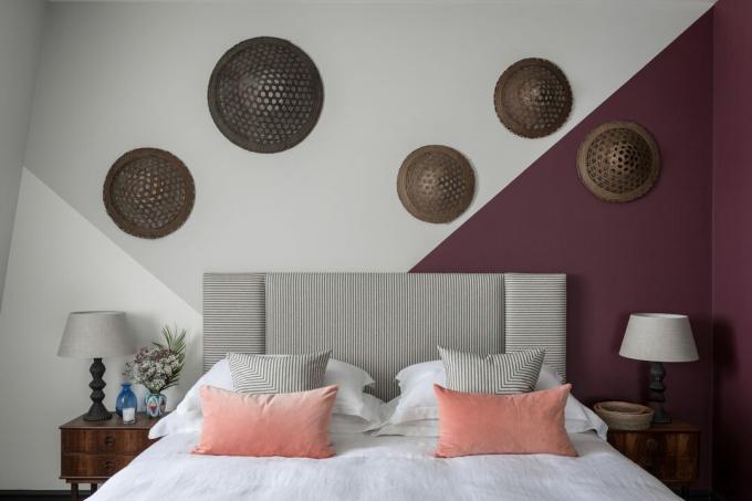 violetinės ir baltos spalvos miegamasis, galvūgalis su juostele, rotango diskai ant sienos