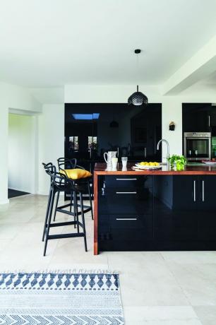ส่วนขยายห้องครัวขาวดำร่วมสมัยพร้อมเกาะครัวขนาดใหญ่และเก้าอี้บาร์ รูปภาพโดย james french