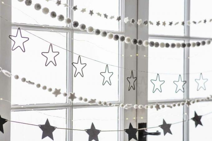 Afișaje de fereastră de Crăciun: ghirlande de pâslă întinse peste fereastră