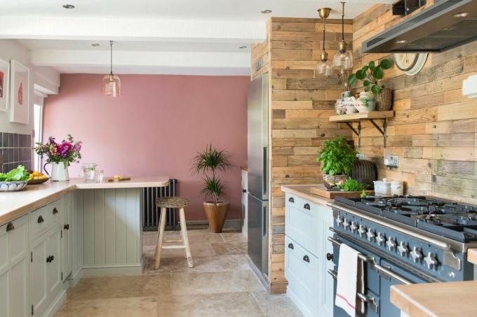 kjøkken med blå komfyr og rosa vegg
